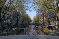 红色的自行车停车桥平静水运河船给轮旅行游客阿姆斯特丹荷兰