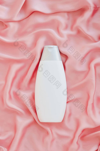 空白标签化妆品容器瓶产品模型粉红色的丝绸背景