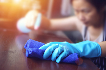 手蓝色的橡胶手套持有蓝色的超细纤维清洁布喷雾瓶消毒解决方案使清洁消毒好卫生