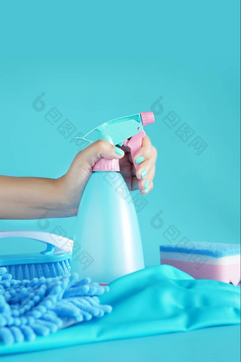 女人手持有清洁喷雾蓝色的塑料瓶洗涤剂