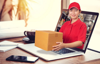 亚洲交付女人红色的衬衫模糊仓库背景持有货物订单包包裹移动PC电脑订单在线交付服务概念