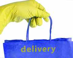 手黄色的橡胶手套持有蓝色的纸袋标签交付快食物交付概念孤立的白色背景剪裁