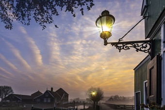 挂路灯柱美丽的典型的荷兰木房子体系结构日出时刻镜像平静运河雍斯安位于北阿姆斯特丹荷兰