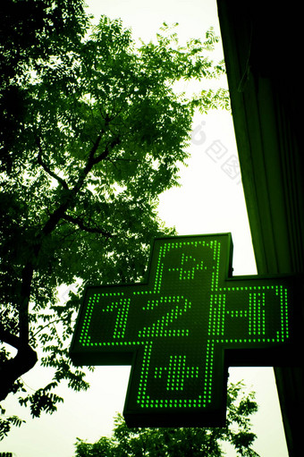 发光的绿色交叉药店标志指示开放十二个小时