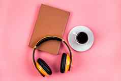 耳机书连接有声读物概念粉红色的桌子上自顶向下
