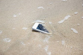 白色移动电话提出海海滩