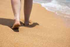女人走光着脚海滩关闭腿年轻的女人