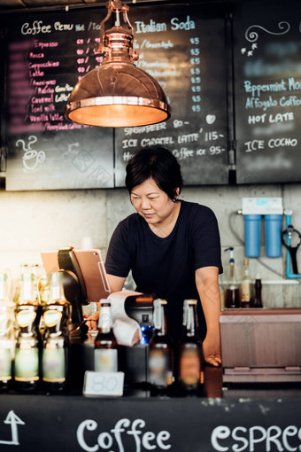 亚洲女人工作收银员服务咖啡商店