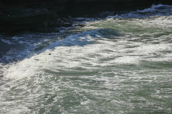身份不明的冲浪者下降冲浪板石头光天化日之下海滩巴厘岛印尼冲浪者扔董事会苍蝇空气掌握海洋燕子背景