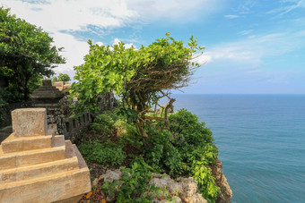 视图Uluwatu悬崖展馆蓝色的海巴厘岛印尼美丽的风景普拉崇高Uluwatu寺庙色彩斑斓的花前景一天风景优美的沿海景观<strong>高悬</strong>崖