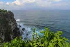 视图Uluwatu悬崖展馆蓝色的海巴厘岛印尼美丽的风景普拉崇高Uluwatu寺庙色彩斑斓的花前景一天风景优美的沿海景观高悬崖