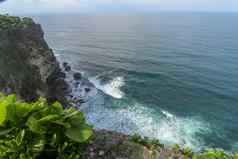 视图Uluwatu悬崖展馆蓝色的海巴厘岛印尼美丽的风景普拉崇高Uluwatu寺庙色彩斑斓的花前景一天风景优美的沿海景观高悬崖