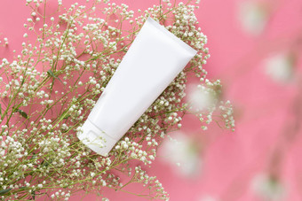 化妆品自然有机护肤品概念白色化妆品管容器空白标签品牌包装模拟装修白色花粉红色的背景复制空间