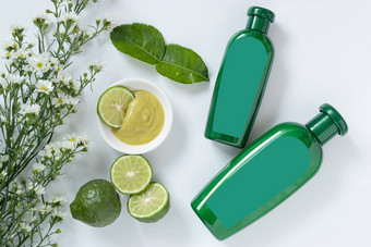 自然产品头发概念大小绿色塑料瓶空白标签Herbal佛手柑洗发水装修幻灯片非洲高粱酸橙非洲高粱叶白色花白色背景图片