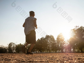 亚洲高级男人。慢跑公园日落天空背景亚洲高级男人。慢跑公园日落天空背景健康的生活方式医疗保健概念
