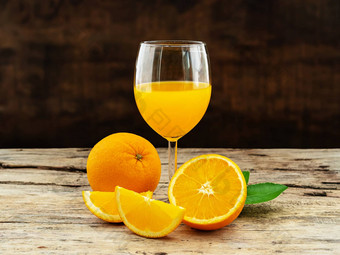 玻璃新鲜的橙色汁集团新鲜的橙色水果绿色叶子木背景水果产品显示蒙太奇工作室拍摄