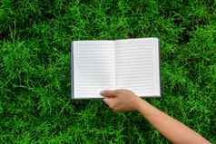 女人”手持有空白笔记本背景夏天绿色公园