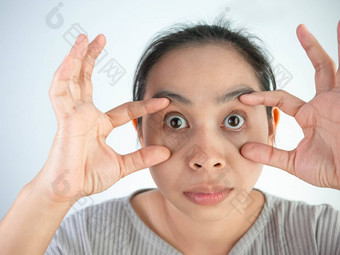 亚洲女人痛苦眼睛疼痛Isolatedon灰色背景健康护理概念