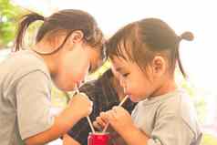 亚洲孩子女孩妹妹吃水管公园