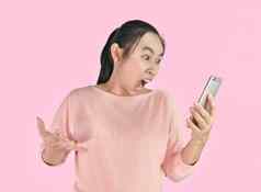 亚洲女人愤怒的愤怒的智能手机孤立的粉红色的背景