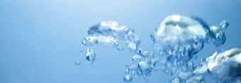 空气泡沫不断上升的表面蓝色的纯水摘要背景