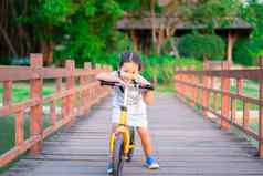 肖像女孩骑平衡自行车桥