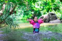 亚洲女孩穿充气袖子玩自然水分
