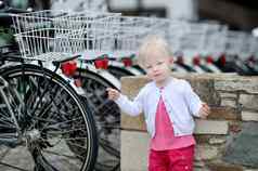 可爱的女孩站行自行车