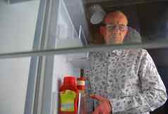 肖像饿了男人。食物冰箱吃饮食概念困惑中年男人。食物空冰箱厨房