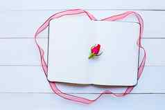 日记笔记本玫瑰丝带白色木背景