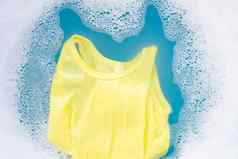 黄色的孩子无袖衬衫浸泡婴儿洗衣洗涤剂水