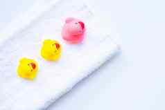 粉红色的黄色的鸭玩具白色毛巾孩子们浴概念