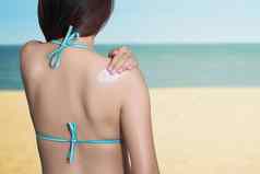 女人应用防晒霜回来海背景防晒系数防晒霜保护概念旅行假期