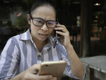 强调业务亚洲年轻的女人持有智能手机工作会说话的电话咖啡咖啡馆<strong>不开心</strong>脸