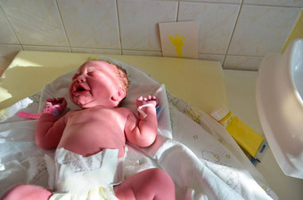 出生婴儿女孩剩余部分脐绳成功的分娩真正的生育出生婴儿医院健康的女新生儿婴儿女孩检查采取婴儿的足迹分娩