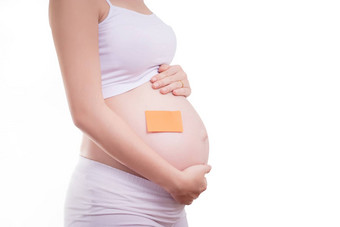 怀孕了女人空白坚持记事本肚子匿名脸美丽的亚洲女模型怀孕了女人孤立的白色背景