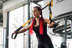 运动员女人培训锻炼悬架系统室内健身房美丽的高加索人运动型女人伸展运动力量锻炼特殊的带