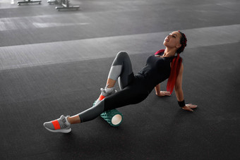 女人按摩泡沫卷腿健身房肌筋膜释放锻炼滚动<strong>触发</strong>点