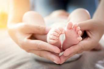 快乐的关系家庭概念新生儿婴儿脚妈妈。手父持有小脚新生儿婴儿手温柔的护理软焦点