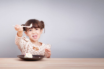 孩子们享受吃概念快乐可爱的混合比赛女孩享受吃蛋糕笑脸脸舌头坚持勺子手邀请吃孩子海报背景