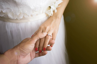 婚礼爱夫妇概念新郎把婚礼环新娘手指婚礼一天事件日出效果镜头耀斑