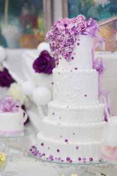白色婚礼蛋糕装饰紫色的花