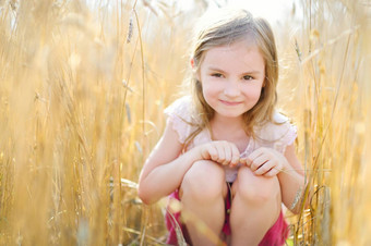 可爱的女孩小麦场温暖的夏天一天