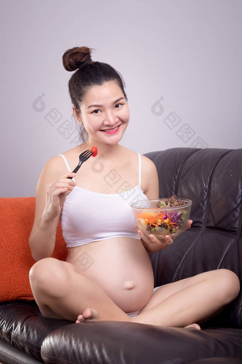 怀孕了<strong>营养</strong>健康的概念快乐年轻的美丽的亚洲怀孕了女人吃<strong>沙拉沙拉</strong>碗沙发笑脸脸健康护理放松首页美丽的亚洲女模型