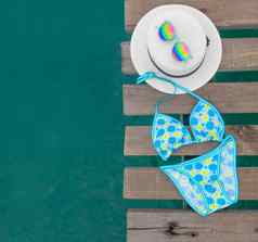 集海滩衣服蓝色的比基尼色彩斑斓的花他太阳镜木桥海表面夏天配件集背景