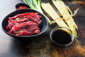 生成分搅拌弗莱中国人面条蔬菜牛肉黑色的碗乡村表格一边视图