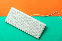 白色电脑键盘橙色绿色背景