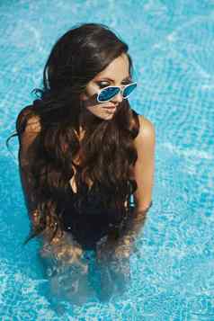 年轻的模型女孩比基尼太阳镜享受阳光明媚的夏天一天游泳池
