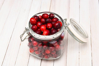 罐头Jar填满新鲜的小红莓白色休息