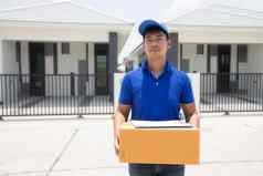 亚洲交付军人穿蓝色的统一的bluecap处理纸板盒子给女客户前面房子在线购物表达交付